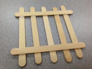 Place a Popsicle stick horizontally on top of the glue dots on both sides.