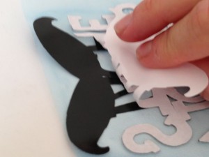 After the vinyl is attached to the transfer tape, peel the backing off the cutout carefully.