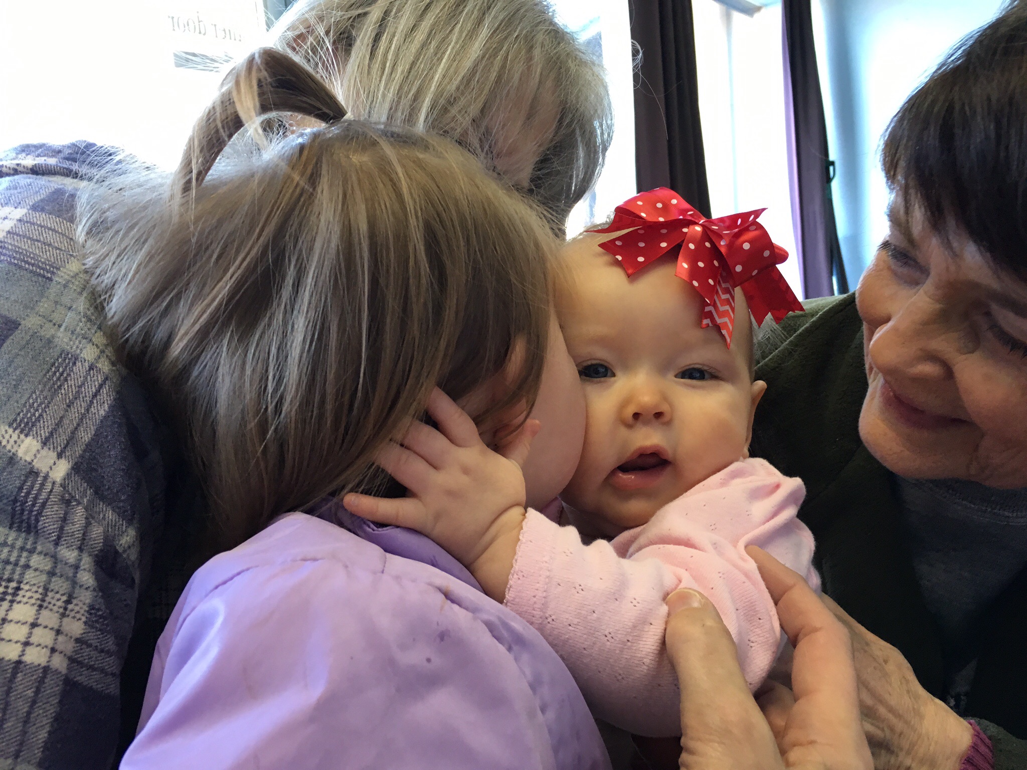 Avery getting kisses from her cousin Hayley.